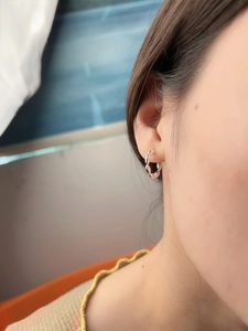 Close-up of minimalist S925 sterling silver hoop earring with twisted rope design on ear