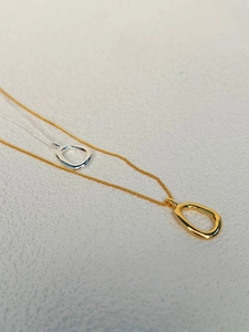 Detail of minimalist 925 silver necklaces with gold and silver water drop pendants
