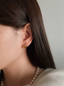Elegant gold heart stud earrings with sparkling zircon on model for a chic style