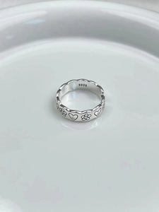Detailed macro view showing the S925 hallmark on the silver heart and sun pattern ring