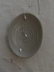 Vue détaillée des pendentifs feuilles en argent avec nervures sur une chaîne délicate