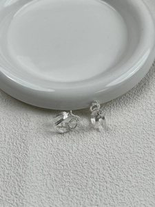 Detail of S925 sterling silver multilayer twisted knot earrings with fine linear texture