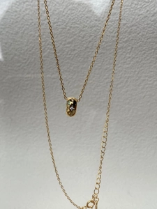Détail du collier pendentif étoile dorée avec oxyde de zirconium sur chaîne croisée