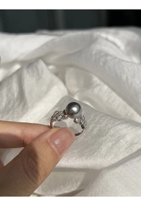 Close-up of a grey pearl ring with sparkling cubic zirconia on a silver band