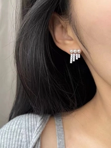 Elegant pearl and zircon tassel earrings worn to show the hanging fringe length and shine