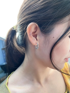 Close-up of minimalist S925 sterling silver twisted rope hoop earring on model ear lobe