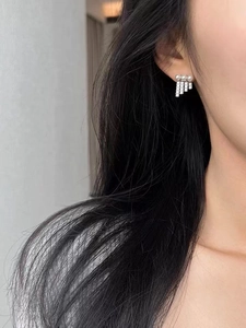 Close-up of S925 silver stud earring with white pearls and sparkling zircon tassels on model