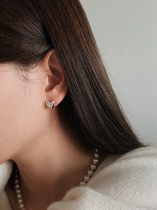 Elegant irregular heart silver stud earring with small diamond on female model