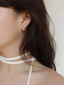 Close-up of a silver multi-layered knot earring made of s925 sterling silver on model