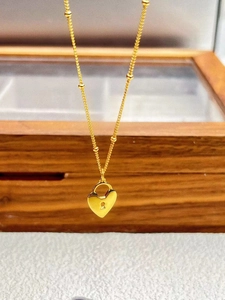 Détail du pendentif coeur en argent 925 sur une élégante chaîne perlée dorée