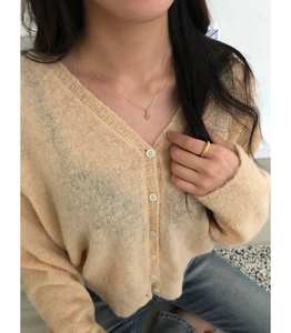 Détail du collier croix en argent 925 doré porté par un mannequin en tenue décontractée