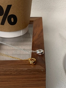 Gros plan de pendentifs anneaux or et argent avec gravures d'étoiles sur chaînes