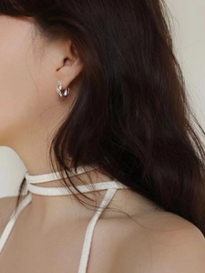 Close-up of minimalist triple-layered silver hoop earrings worn by a model