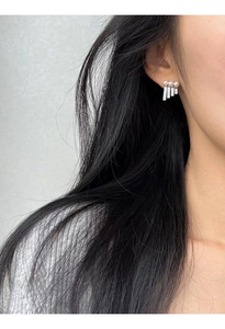 Detail of S925 silver earrings featuring three pearls and shimmering zircon tassels