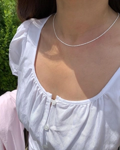 Close-up of minimalist S925 sterling silver shimmering chain worn on the neck