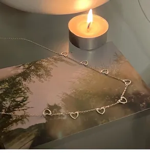 Macro view of sterling silver necklace with multiple open heart pendants on a fine chain
