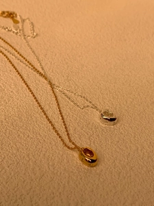 Vue détaillée des colliers étoiles en or et argent avec pendentifs anneaux sertis