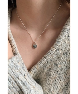 Détail du pendentif cadenas coeur argenté avec diamant bleu et gravure sur un mannequin