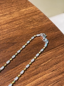 Detailed view of S925 sterling silver stamp on bicolor beaded necklace chain