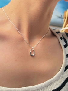 Detail of 925 sterling silver oval cutout pendant necklace on a female model