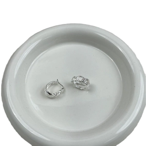 Minimalist S925 sterling silver multi-layer coiled hoop earrings on white ceramic dish
