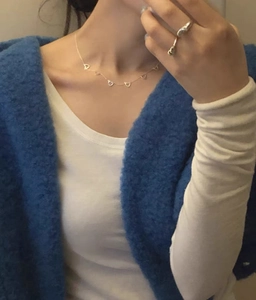 Close-up of minimalist 925 sterling silver chain necklace with hollow heart charms