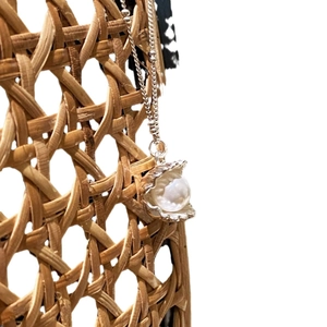 Minimalist s925 silver necklace with shell pendant and pearl on woven background