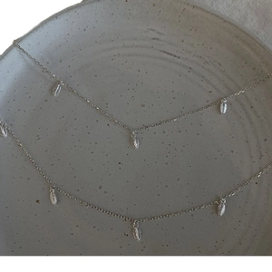 Élégant collier feuilles de cerisier en argent S925 sur une assiette en céramique
