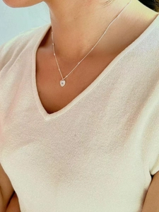 Elegant 925 silver heart necklace with blue gem on a model wearing beige knitwear