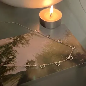 Elegant 925 sterling silver chain necklace with multiple hollow heart pendants on a card