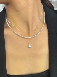 Layered S925 sterling silver beaded necklace with brushed oval pendant on a model