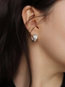 Détail des boucles d'oreilles en argent 925 en forme de coquillage portées par un mannequin