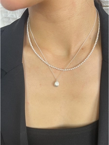 Detail of layered S925 silver necklace with micro pearls and frosted teardrop pendant