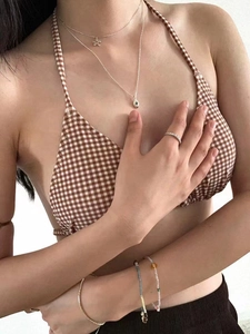 Detailed shot of 925 silver necklace with blue diamond flower pendant on bikini model
