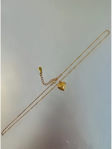 Detailed macro view of 18k gold plated heart pendant with radial texture and clasp chain