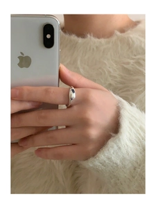 Detail of silver irregular ring featuring a purple gemstone worn during daily use