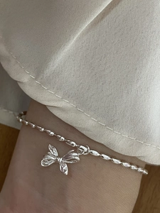 925 sterling silver butterfly charm bracelet with olive bead chain on woman wrist