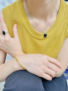 Detail of 925 silver black onyx necklace set with matching ring and gold bracelet