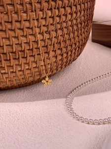 Detail of 925 silver flower necklace with blue crystal and textured golden petals