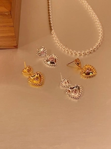 Détail de boucles d'oreilles cœur en argent 925 avec zircon rose et texture tressée