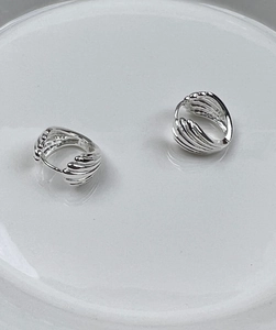 Gros plan de boucles d'oreilles coquillage en argent 925 avec texture côtelée et poli