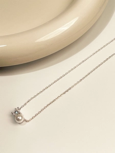 Macro view of sterling silver necklace with freshwater pearl and square zircon pendant