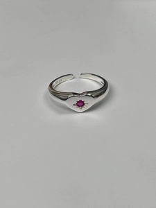 Close-up of S925 sterling silver heart ring with starburst red gemstone setting