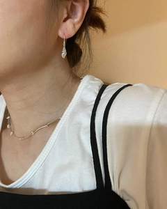 Elegant 925 sterling silver conch shell earrings and bead necklace set worn by a model