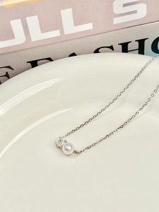 Macro shot of 925 sterling silver chain with natural freshwater pearl and square zircon