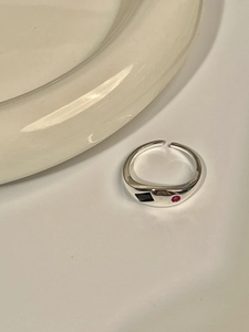 Detailed macro view of S925 silver ring featuring inlaid black and red gemstones