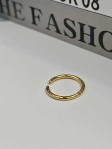 Gros plan d'une bague torsadée en argent S925 plaqué or avec un design ouvert ajustable
