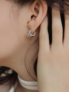 Minimalist silver cat eye stone earrings worn by a model for a chic and stylish look