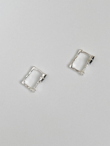 Macro view of textured sterling silver rectangular hoop earrings with black agate insets