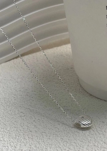 Macro detail of 925 sterling silver heart necklace with unique spiral textured pendant